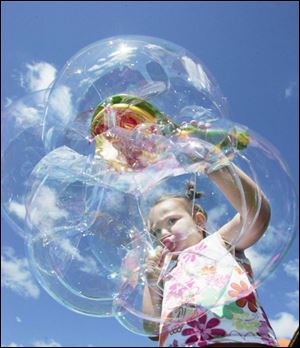 Four-year-old Toledoan Jordyn D'Clute, above, demonstrates the art of blowing soap bubbles, among children's activities at Saturday's Bike-a-Thon and Family Fun Festival in Oregon.