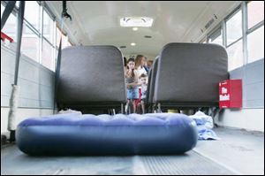 Brionna Caudill, 8, left, and her brother Logan, 3, check out the mattress Matt Geha used in his night on the school bus.