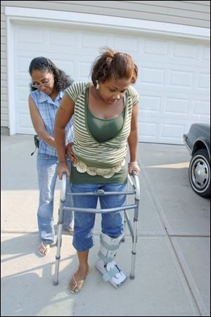 Kim Lampkin helps her daughter, Vena, navigate with the aid of a walker. The driver in the crash was sentenced to six months of monitoring and five years of community control.