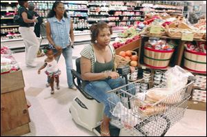 Vena Lampkin uses a motorized cart to shop with her
mother, Kim, and daughter, Rashyra. Prosecutors said they were unable to reach the Lampkins, who now live in Atlanta.