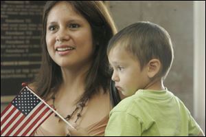 New citizen Melissa Dora Sensmeier, formerly of Peru, is joined by her son Samuel, 2, after the naturalization ceremony that was held downtown yesterday at the U.S. District Court.