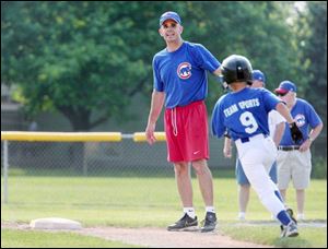 L.J. Archambeau tells his son, Tyler, to round first and head for second during a Little League game at Fairfield Elementary School. Coaching the team gives him time with his son and a chance to help others, too.