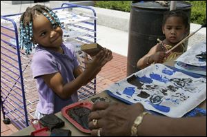 Unique Washington, 4, left, and her sister, Asia Means, both of Toledo, make mud cloth at a craft station at the museum. 