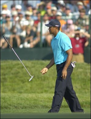 Tiger Woods flips his putter after missing a par putt on No. 18.
