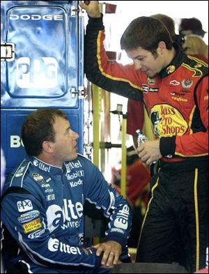 Ryan Newman, left, and Martin Truex Jr. talk in the garage area of Michigan International Speedway, near the Motor City.