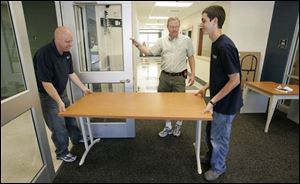 Principal Gary Devol, center, assists Vince Whitacre, left, and Todd Polker inside the new Keyser Elementary School.