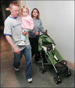 Hens infielder Kevin Hooper carries daughter, Lucy, as he leaves the ballpark with his wife, Lindsey.