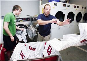 Jake Garber, and Mud Hens clubhouse manager Joe Sarkisian wash the players uniforms after the game.