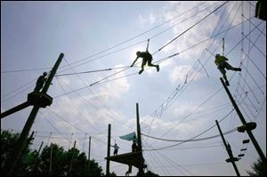 Niv Koren, center, of Israel climbs fearlessly on high ropes at the 2007 World Oncology Camp at YMCA Storer Camps in Napoleon, Mich. After all, Niv and 47 other children have stared down far worse: cancer. 