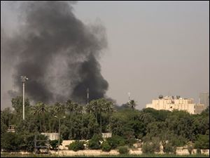 Smoke rises over a heavily protected Green Zone in Baghdad, Iraq, that houses the US Embassy and Iraqi government after a volley of mortars landed Thursday, June 21, 2007.