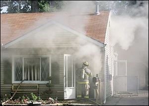 A Toledo firefighter enters the burning Katafiasz home this morning.