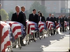 Pall bearers enter a memorial service with the caskets of nine fire fighters in Charleston, S.C., Friday, June 22, 2007. The nine firemen were killed Monday battling a blaze at a furniture store. 