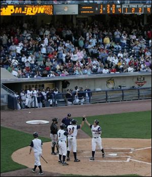 The Hens' Jack Hannahan is greeted by teammates after homering last night in Toledo's win over the Indians at Fifth Third.