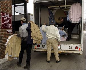 Volunteers unload a truck of clothing and carry it into the Cherry Street Mission s donated clothing shop. The mission offers rehabilitative services as well as food, shelter, and clothes.
