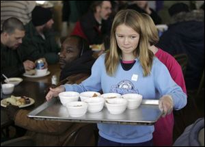 A young volunteer serves a dessert during Thanksgiving 2006 at the Cherry Street Mission Community and Food Services Building. Volunteers, like this girl, have been helping the center meet its mission since 1947. Sixty years later, the need for its ministries is larger than ever.