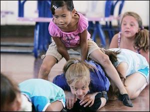 At right, Hannah Lagger, 7, of Lambertville takes a big hop and passes over Madison Monroe, 9, of Temperance. 