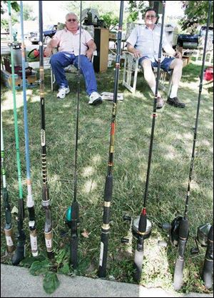Bill Wagner, left, and his friend Jerry Kaiser bide their time behind an array of fishing poles that were for sale at the home of Mr. Wagner in Metamora, Ohio.