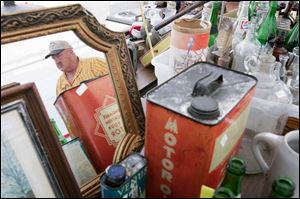 That's Tom Huff of Berkey, Ohio, shown in the mirror, among his offerings in the Historical Old Territorial Road garage sale.