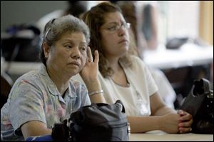 Sue F. Law, left, and Elisa Martinez listen to Gov. Ted Strickland at the Mayores Senior Center.
