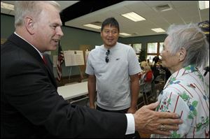 Gov. Ted Strickland, left, meets with Hugh Woo of Point Place and his mother, Fay Woo, at the Mayores Senior Center in South Toledo. The governor yesterday discussed with senior citizens the state's new property tax exemption that is part of a new biennial budget that awaits his signature. He is expected to sign the bill tomorrow, the last day of the fiscal year.