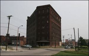 A century-old former warehouse known as the Triangle Building on South Erie Street is sold to a Lansing developer.