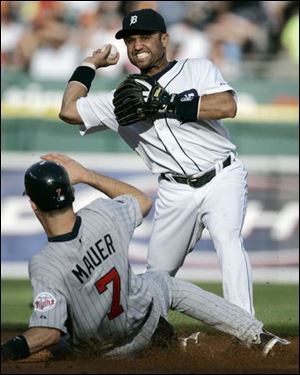 The Tigers' Placido Polanco tries to complete a double play but fails in the first inning.