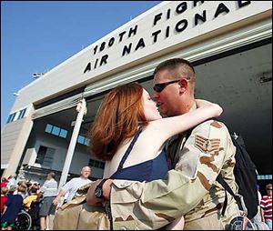 Amber Meyer, of Waterville, hugs her husband, Sgt. Douglas Meyer, who is among 200 airman returning to Toledo from Iraq.