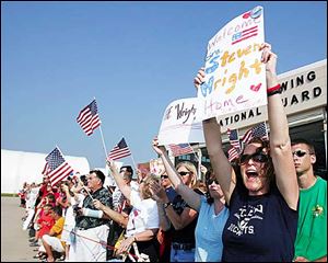 Nell Wright, right, of Mansfield, yells with family members and friends as more than 200 airmen return to Toledo from Iraq.