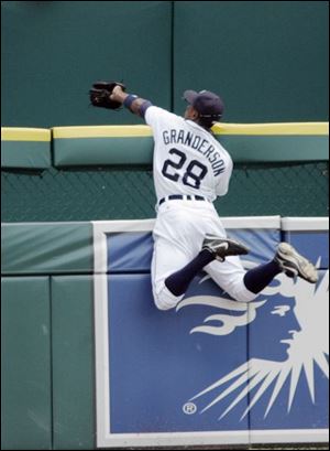 Detroit center fielder Curtis Granderson goes over the fence to rob Boston's Wily Mo Pena of a home run in the fourth inning. Granderson leaped in full stride to catch the ball about two feet beyond the top of the fence.
