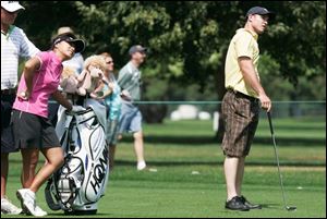 Mi Hyun Kim, left, watches a shot by the Mud Hens  Jack Hannahan   he s watching too   during yesterday s UnitedHealthcare Celebrity/Pro Challenge at Highland Meadows.