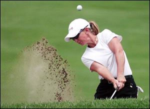 Carri Wood blasts out of a trap on the fifth hole, where she got a double bogey, but she finished 1-under for the day.