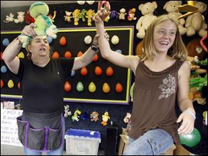 Slug: REG seneca26p A           The Blade/Jeremy Wadsworth     Date: 07/25/07                    Location: Tiffin, Ohio. Caption: Brooke Kistler, 12, of Tiffin, Ohio, gets her hand raised in victory by Cindy Stevens after winning a stuffed frog in a dart game Wednesday, 07/25/07, at the Seneca County Fair in Tiffin, Ohio.     Summary:  Fair theme: "Seneca County Fair, where friendships are made" The fair runs from July 23rd to July 29th.