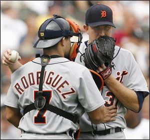 The Tigers' Zach Miner explains to catcher Ivan Rodriguez his strategy for pitching the ninth inning. The White Sox's Scott Podsednik crossed up the Tigers and he scored on Miner's error.