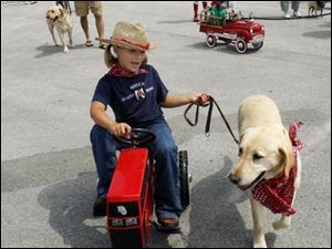 Slug: CTY-NBRE dogs02p D           The Blade/Jeremy Wadsworth     Date: 07/28/07                     Location: Oregon, Ohio. Caption:  Molley Baumgartner, 6, of Northwood, Ohio, with her dog Sydney during a parade at the  2007 Dog Days of Summer Festival at  The Little Sisters of the Poor Saturday, 07/28/07, in Oregon, Ohio.  Summary: The Little Sisters of the Poor are calling out the dogs for the 2007 Dog Days of Summer Festival today.