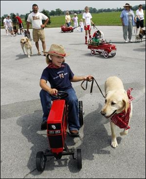Slug: CTY-NBRE dogs02p D           The Blade/Jeremy Wadsworth     Date: 07/28/07                     Location: Oregon, Ohio. Caption:  Molley Baumgartner, 6, of Northwood, Ohio, with her dog Sydney during a parade at the  2007 Dog Days of Summer Festival at  The Little Sisters of the Poor Saturday, 07/28/07, in Oregon, Ohio.  Summary: The Little Sisters of the Poor are calling out the dogs for the 2007 Dog Days of Summer Festival today.