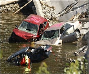 A diver searches a car in the rubble of the I-35W bridge, at left. Dive conditions were hazardous, with a visibility of only about six inches.
