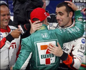 Tony Kanaan, left, is congratulated by Dario Franchitti after winning the Firestone Indy 400. Franchitti was knocked out of the race after a spectacular crash with about 60 laps left.