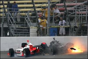 Helio Castroneves  car, left, comes to rest against the wall with Vitor Meira s car after a crash in Brooklyn, Mich.