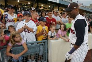 Marcus Thames, who is in Toledo on a rehab assignment, signs autographs during last night s two-hour rain delay.
