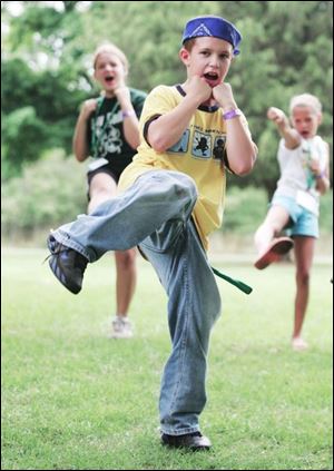 Cameron Corbett of Warren, Ohio, gets a kick out of karate class as he learns some new moves at Operation: Military Kids at the 4-H camp on Kelleys Island.