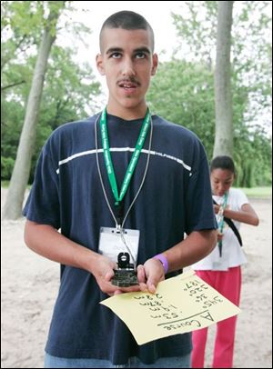 Toledoan Chris Eschareno helps campers with compasses on Kelleys Island. Ohio s outreach effort in the nationwide initiative is geared to children from ages 9 through 14.