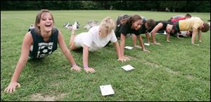 From left, Taylor Deady of Cable, Ohio, Samantha Dunn of Chillicothe, Ohio, and Rachel Harris of Columbus find push-ups are more fun if they have a sense of humor during Operation: Military Kids. 