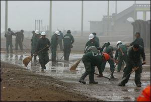 Workers clean the Lima, Peru, seafront after it was hit by heavy waves caused by Wednesday's earthquake.