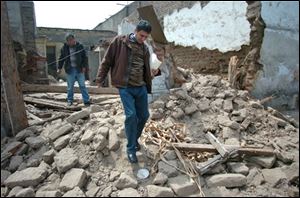 Members of the Peruvian Civil Defense inspect a building damaged during Wednesday's earthquake.