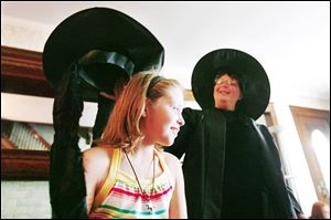 In her proper costume as a transfiguration specialist Cheryl Jackson, right, places a magical hat on Elizabeth Teczynski.