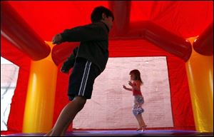 Nathaniel Archibeque, left, and Sophie Strawbridge expend some energy as they hop around in an outdoor inflatable toy, part of the festival fun for kids. The festival runs through 6 today.