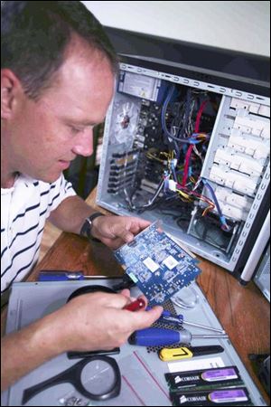 Kelly Lewis works on a computer at his home in Sylvania. His IT studies at Stautzenberger College have led to a new job and a side business building computers.