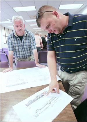 Willy van Bakel, left, and Charles Bryan of Wauseon Downtown Development talk over a proposed project consisting of a hotel and shops to replace that portion of the city's downtown that was destroyed by fire in April.