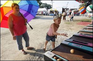 Tammy LaLonde and daughter Chrissy, 9, try for a prize at one of the midway games.