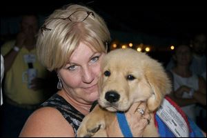 Jenni Yoder with a puppy at the Dealin  For Dogs fund-raiser.